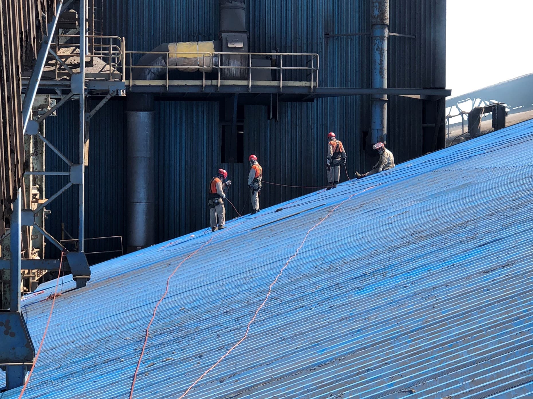 Cuadrilla de AMS trabajando sobre una cubierta industrial